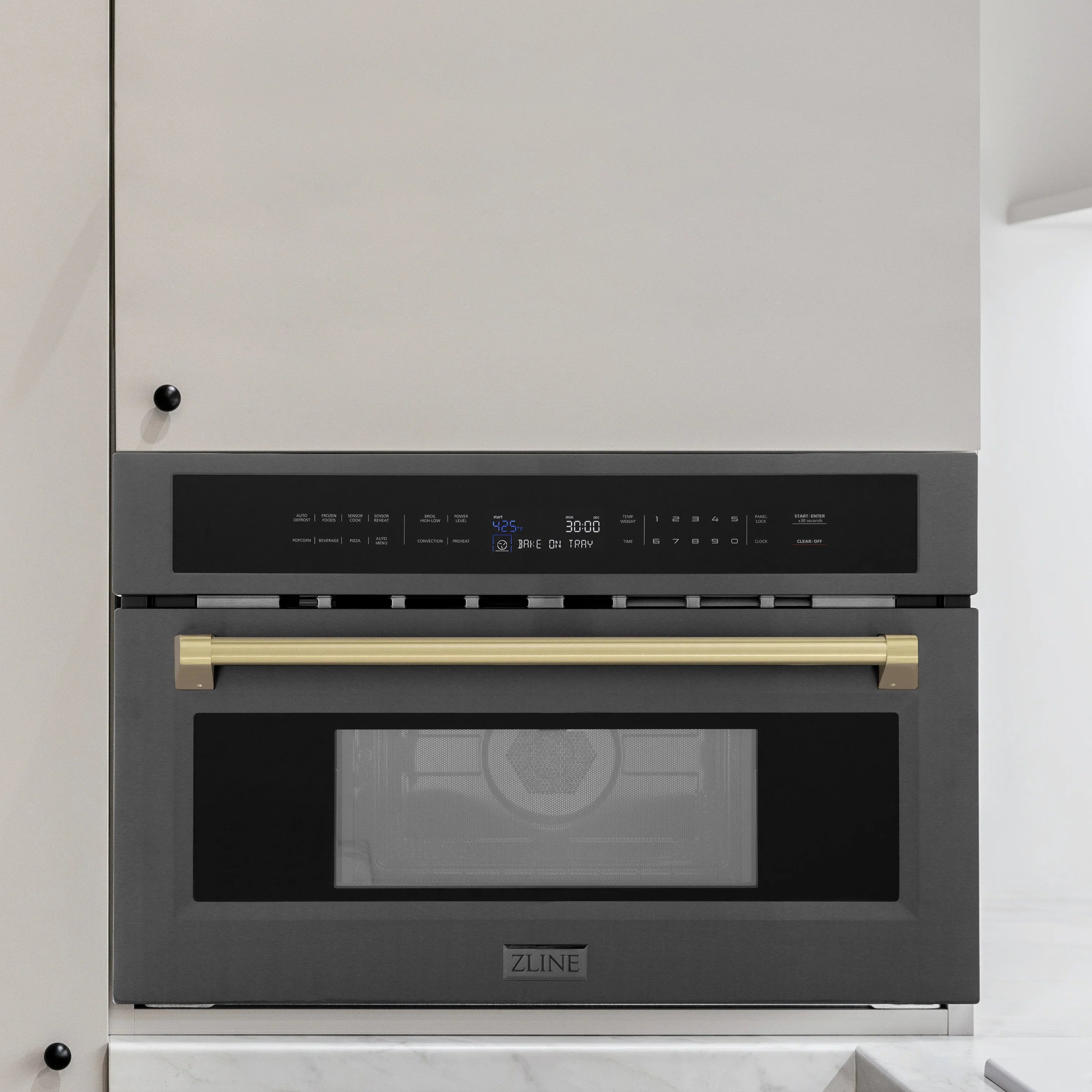 Black stainless steel single wall oven installed in cabinetry with champagne bronze trim