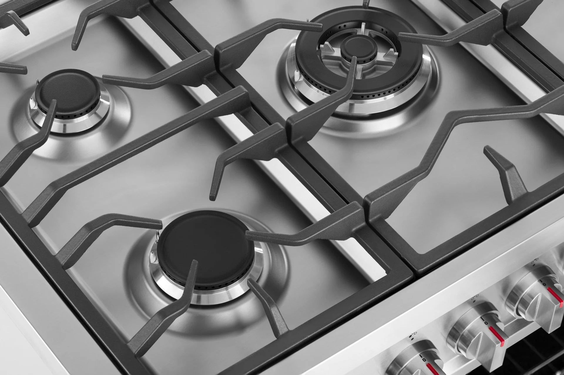 Stainless steel gas cooktop with four burner grates and silver burner caps
