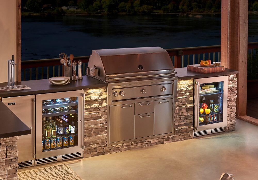 Stainless built-in outdoor refrigerator with glass door in an outdoor kitchen setting