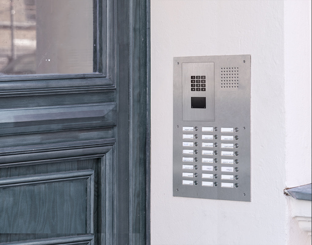 Wall-mounted stainless steel access control keypad with speaker grille and black display