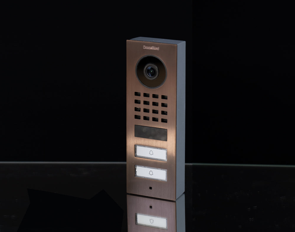 Bronze outdoor video door station side view with camera, speaker grille, and two call buttons