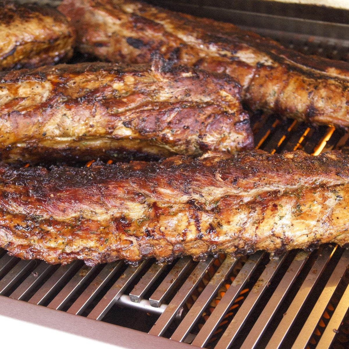 Natural gas built-in grill with roasted meat on cooking grates