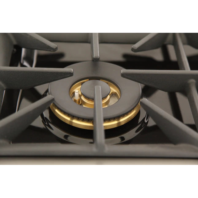 Gas burner head with gold center cap and black grates inside a dual fuel range