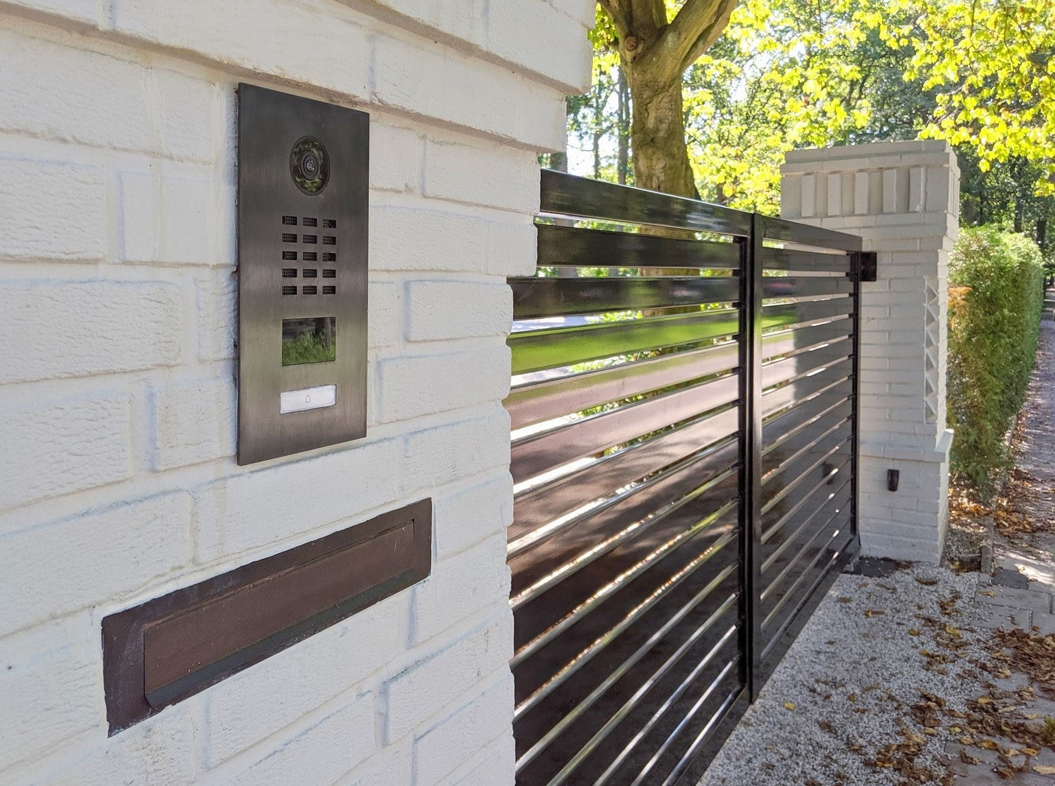 Titanium video door station mounted on exterior wall with call button and camera
