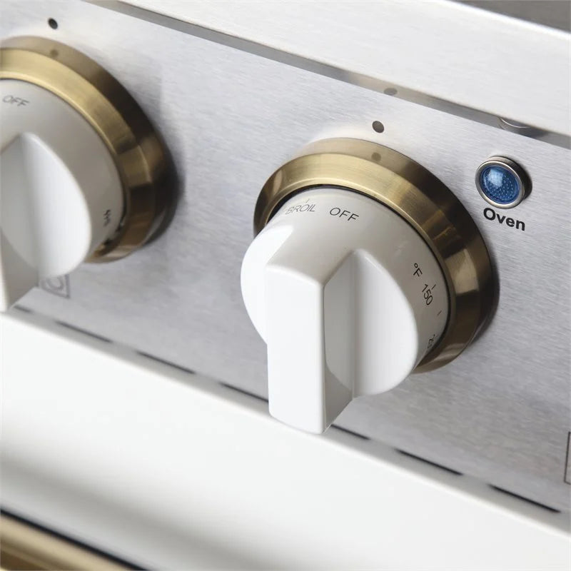 Close-up of white oven and burner control knobs on stainless front with labels