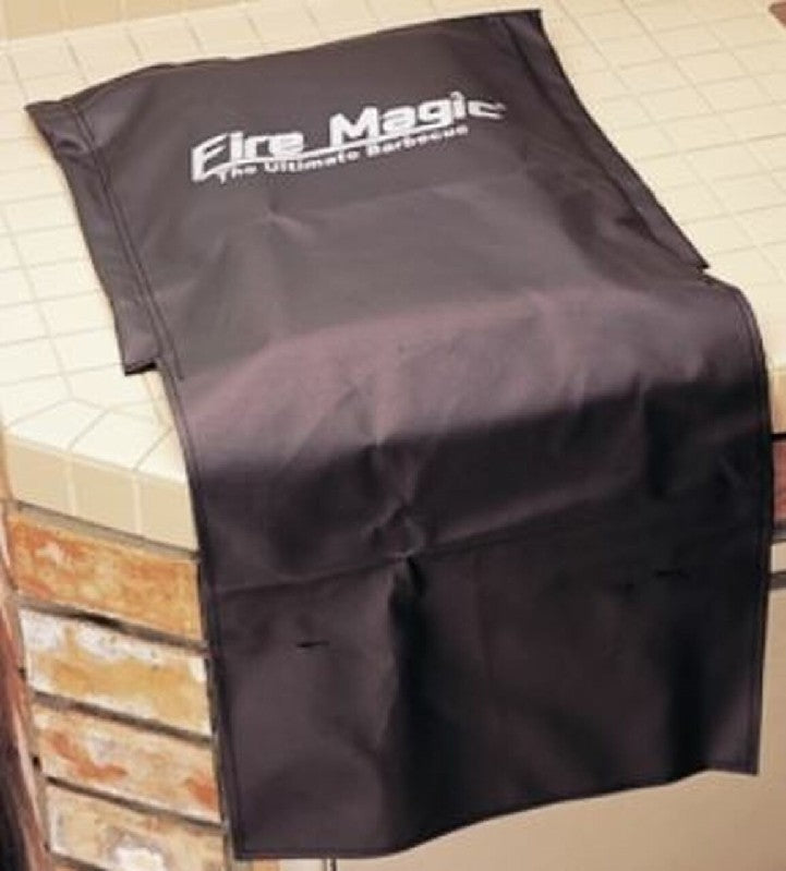 Dark vinyl grill cover with Fire Magic branding, fitted shape for side burner and caddy areas