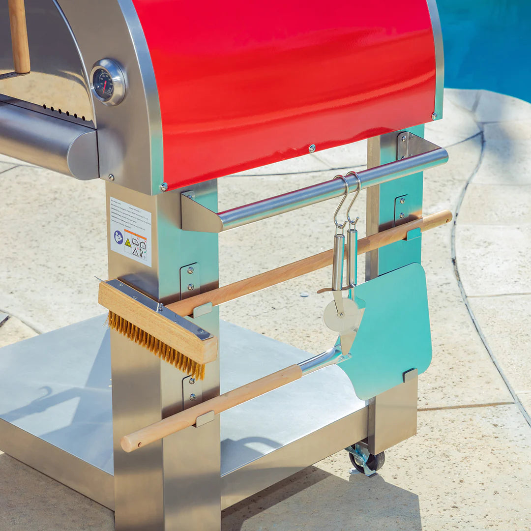 Wood fired pizza oven side with stainless frame and wooden-handled accessory tools
