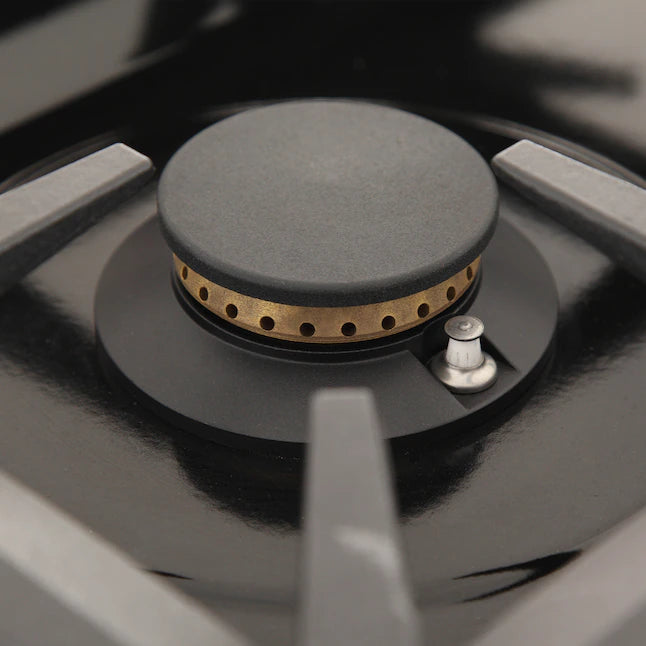 Stainless steel gas range burner with round gray cap and small control knob beside it