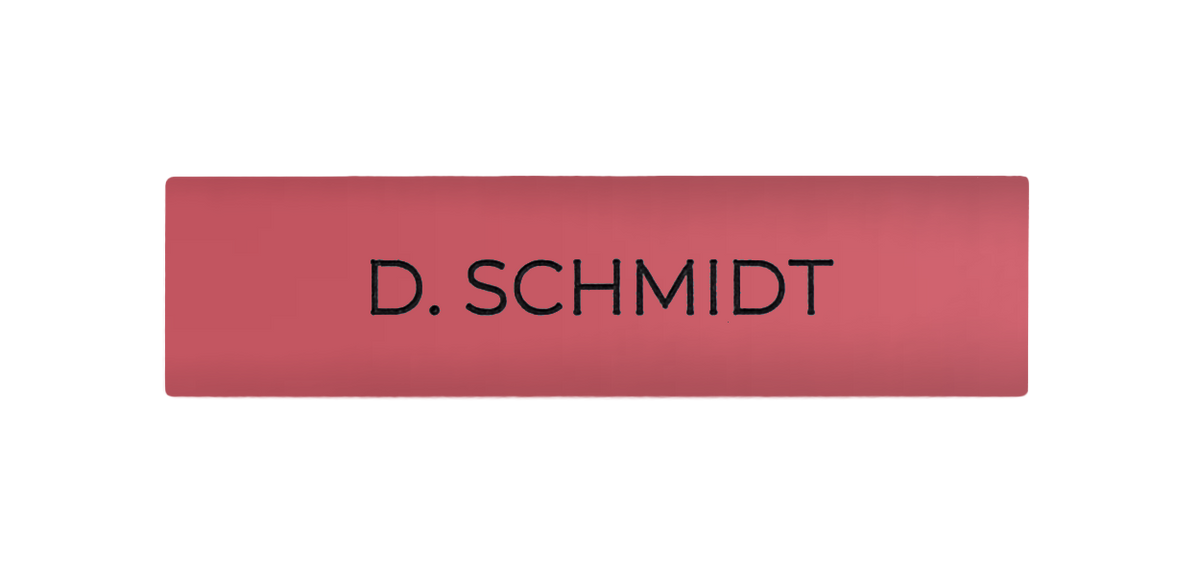 Antique pink door nameplate with black engraved text: D. SCHMIDT