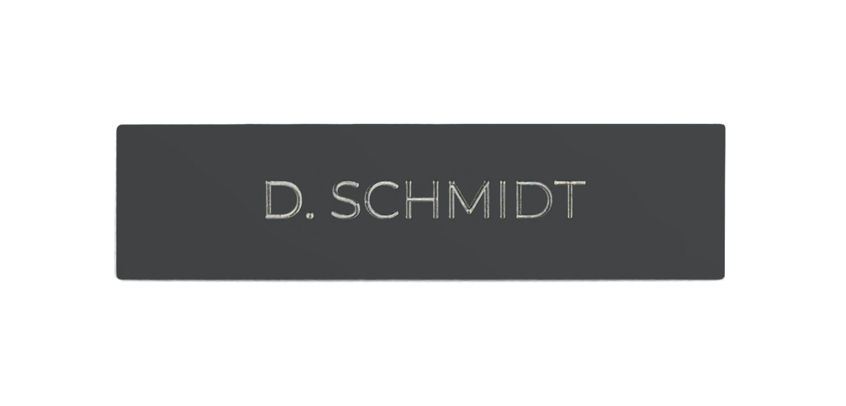 Rectangular dark grey metal nameplate with engraved 'D.SCHMIDT' lettering