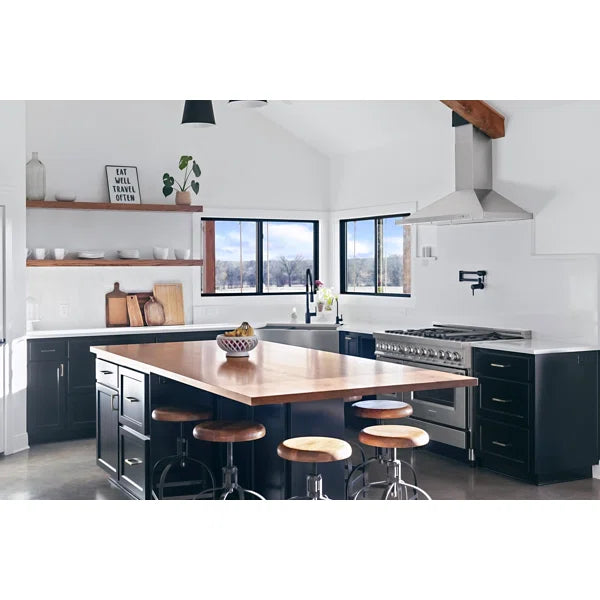 Stainless steel convertible wall mount range hood above a kitchen island cooktop