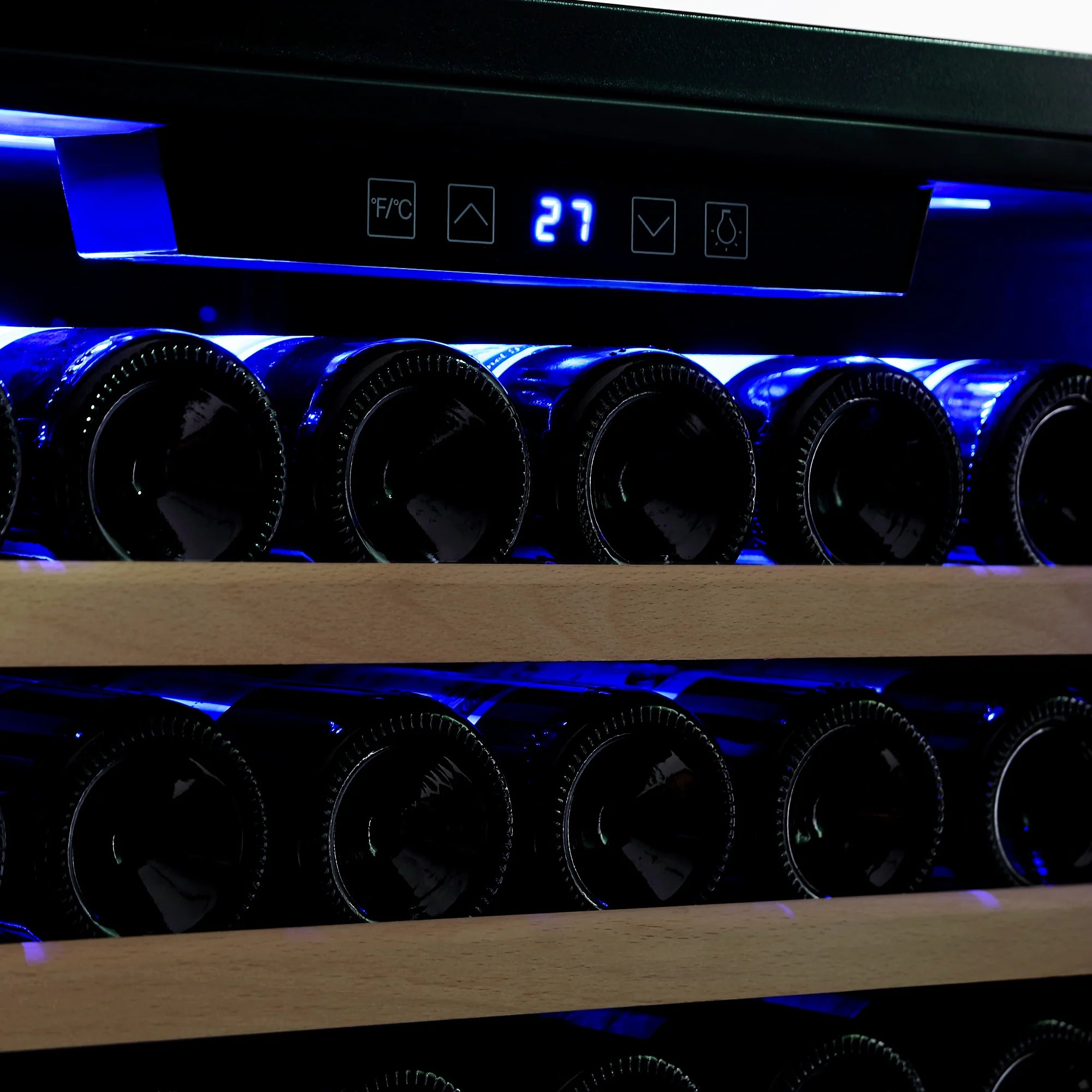 Wine cooler with illuminated bottle racks behind dark glass door