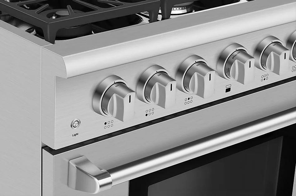 Stainless steel gas range control knobs with indicator markings along the front