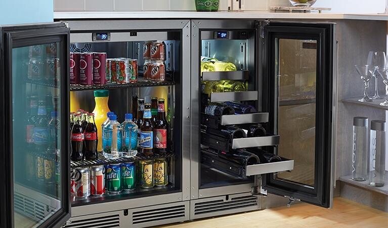 Stainless wine cooler with open glass doors, stocked with bottles on interior racks