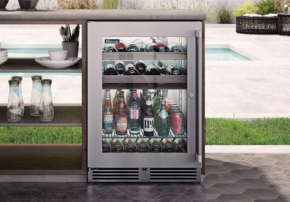 Perlick outdoor beverage center with open clear glass door and stocked bottle shelves