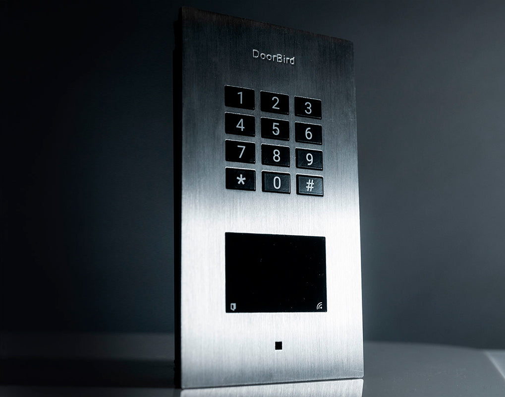 Front view of stainless steel DoorBird access control device with keypad and black display
