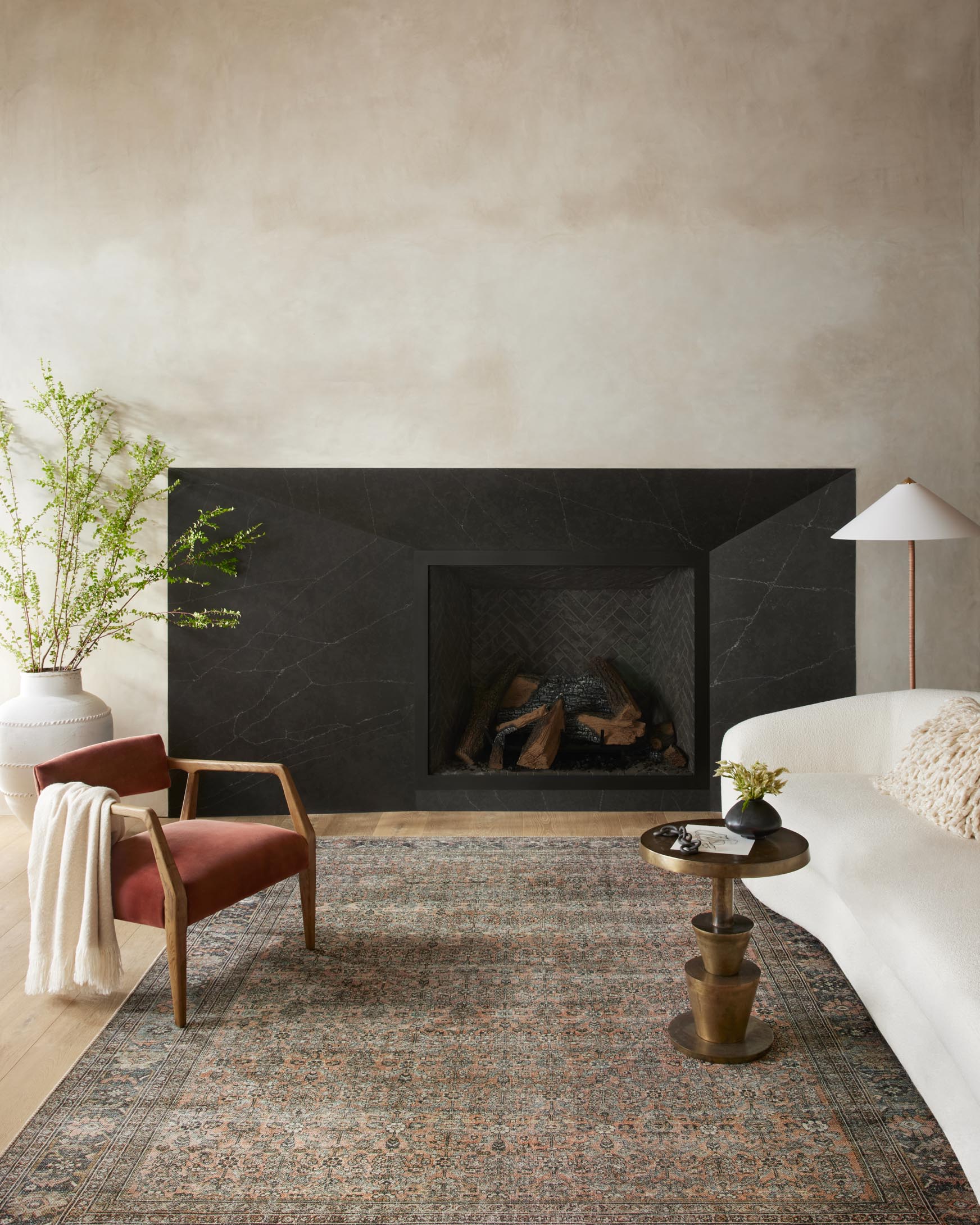Traditional multicolor area rug laid in a living room, ornate pattern in terracotta and blue