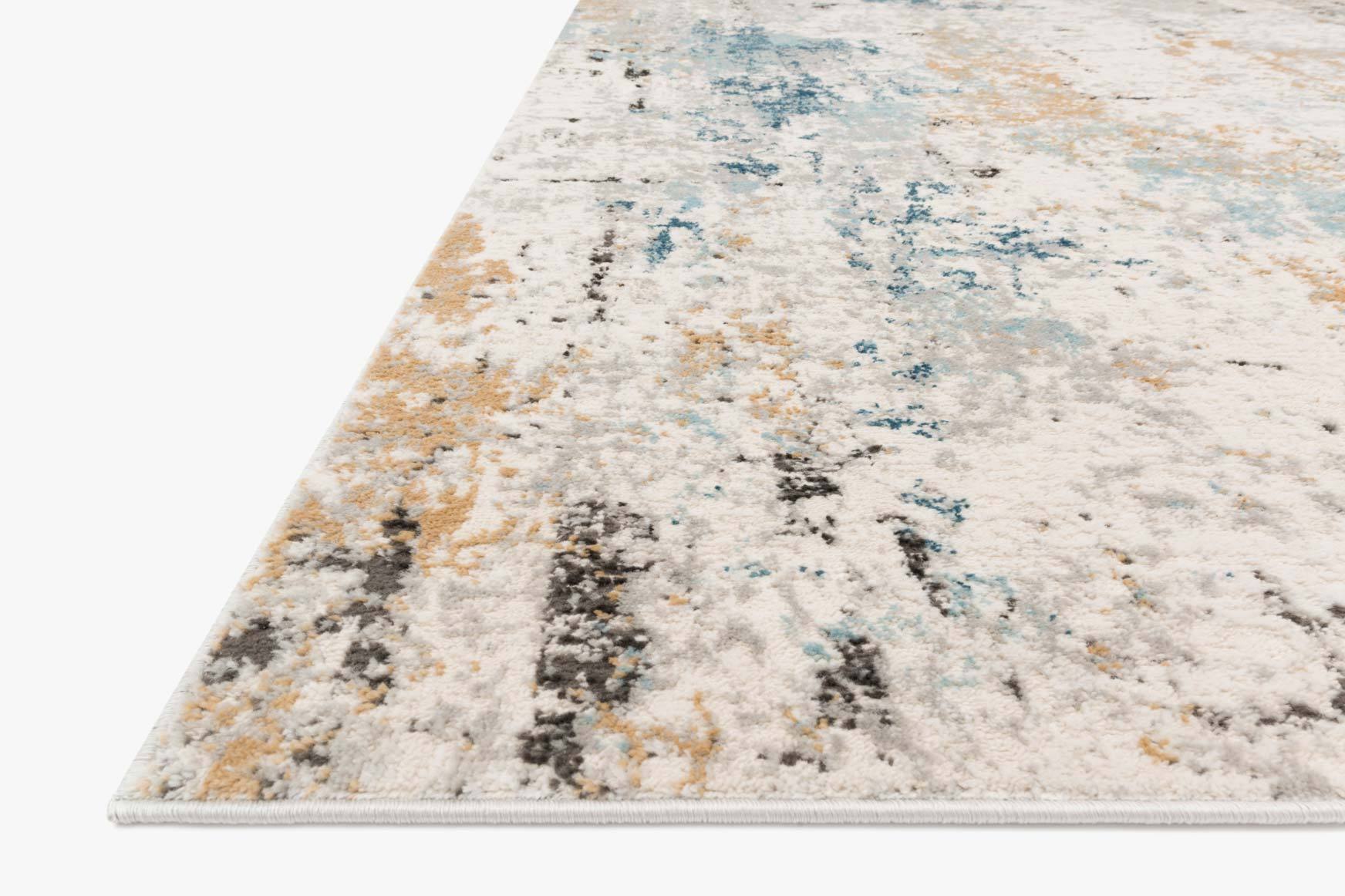 Corner close-up of stone-and-slate power-loomed rug with distressed abstract cream and blue.
