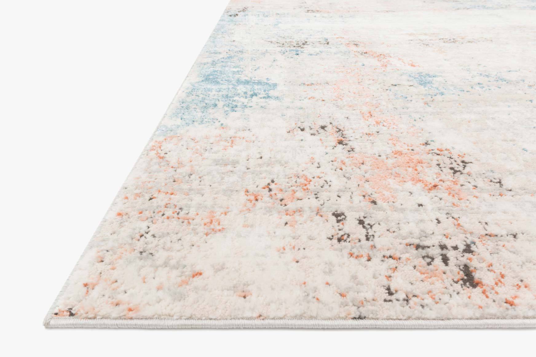 Ivory rug corner with diagonal abstract pattern in blue, orange, and gray flecks