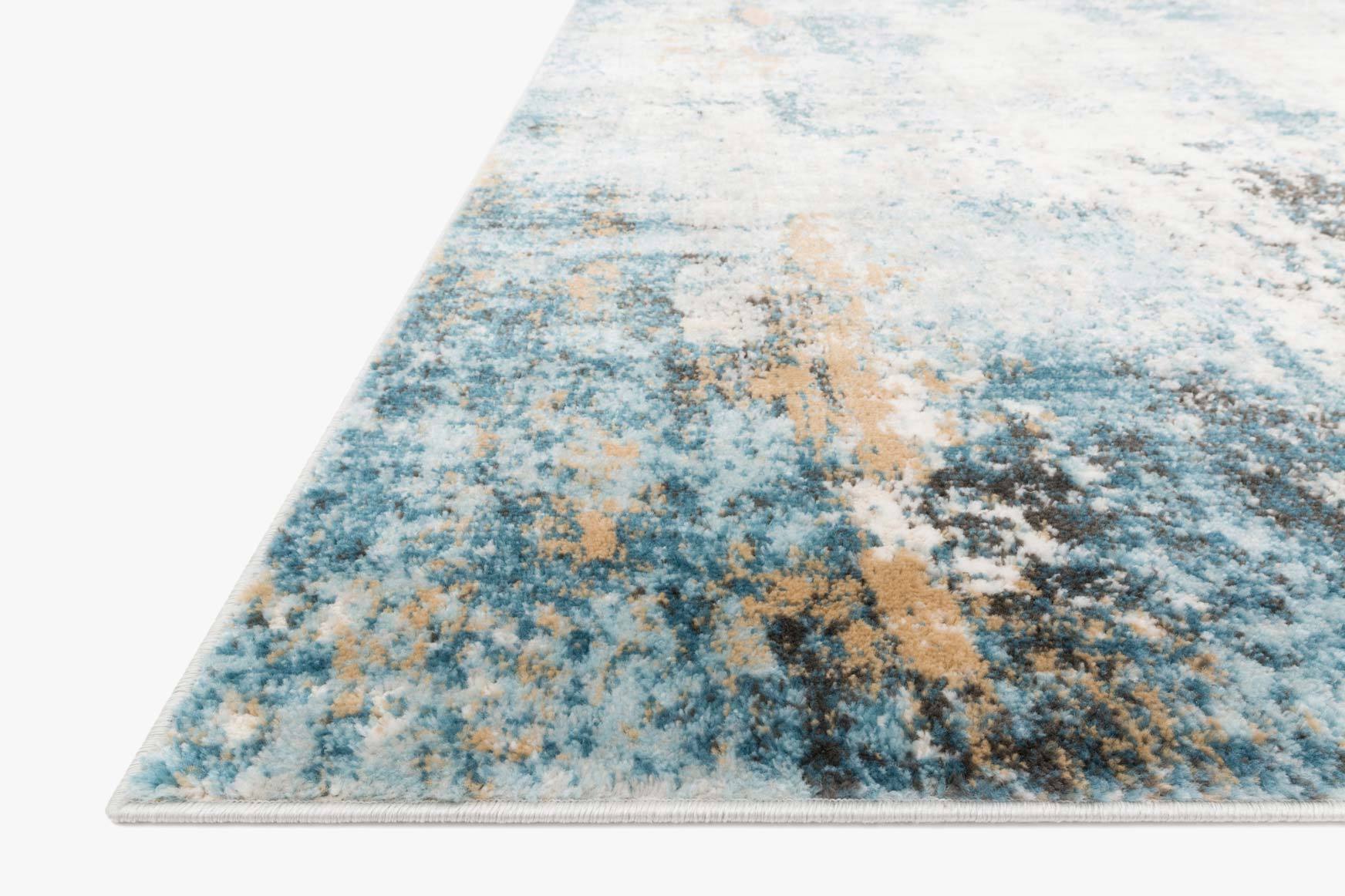 Corner close-up of a denim blue and ivory power-loomed rug with distressed abstract print