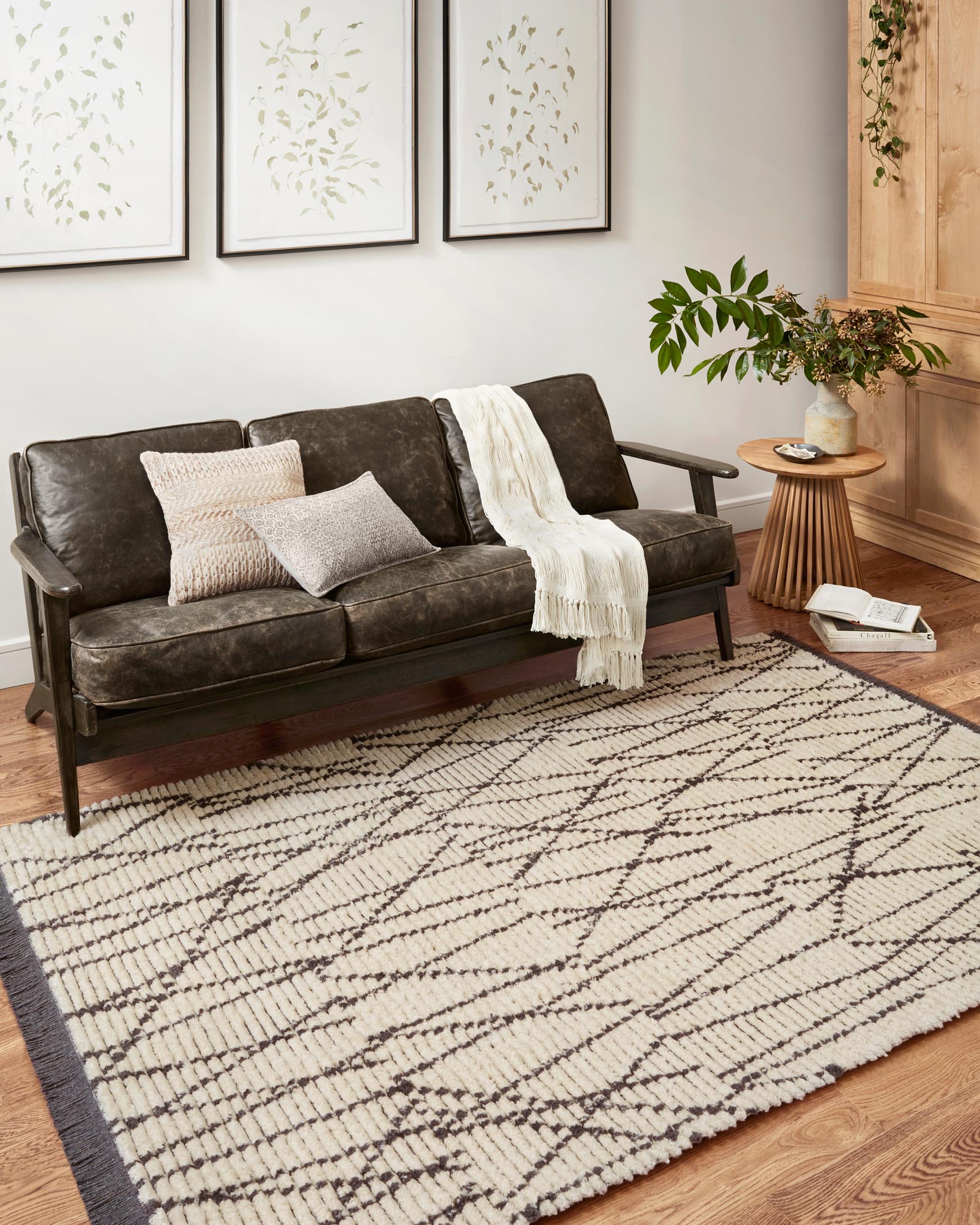 Cream and charcoal geometric rug in living room with short fringed border
