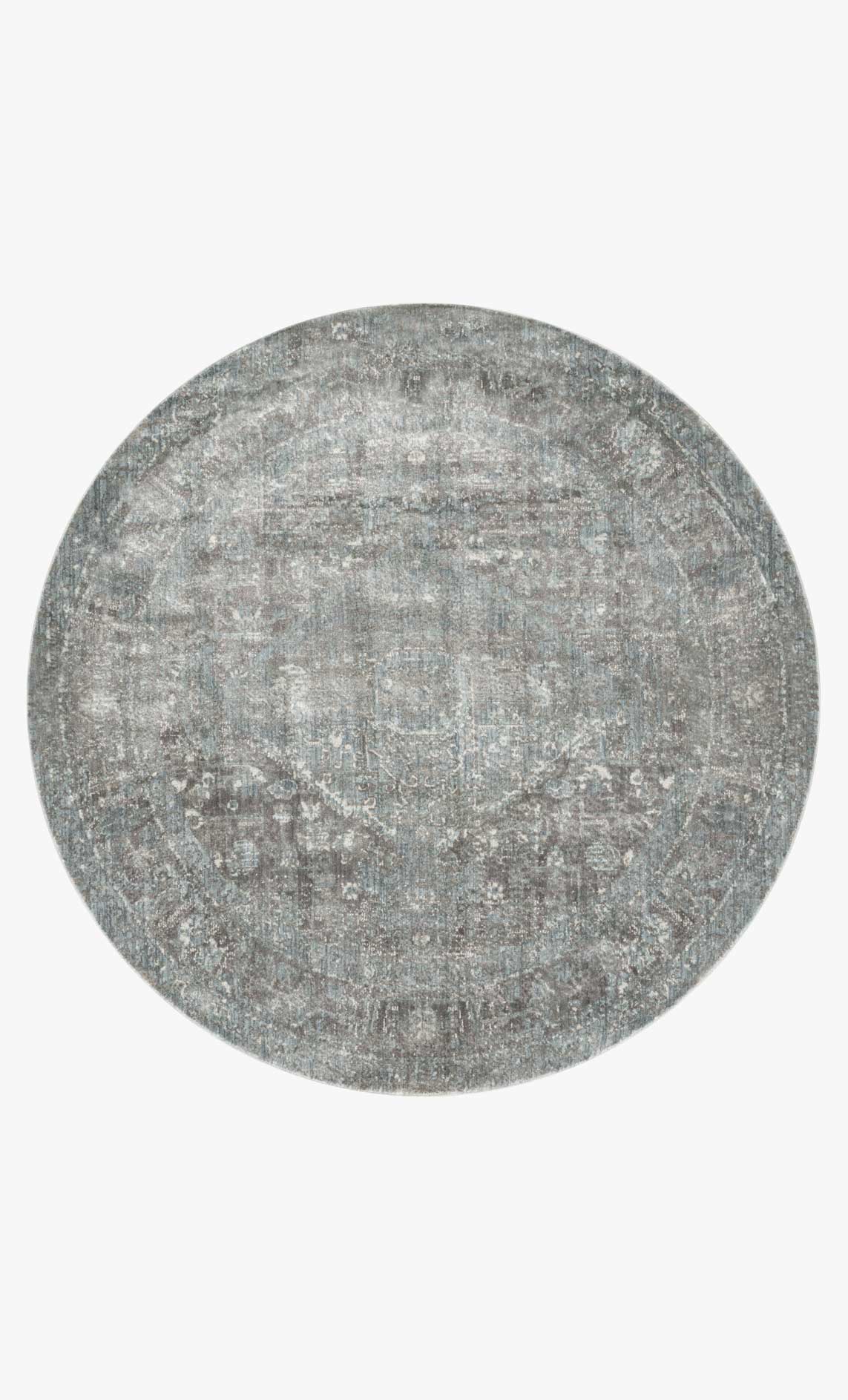 Round rug in stone with muted blue distressed geometric pattern