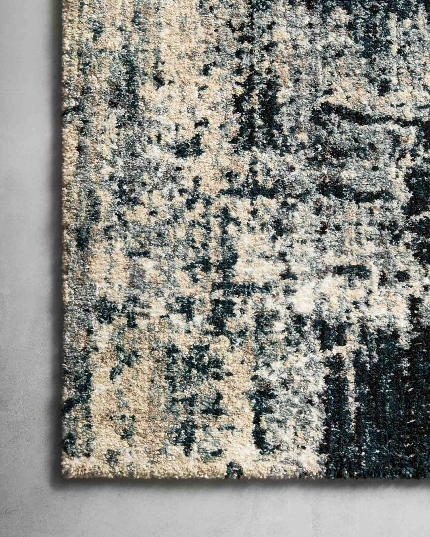 Power-loomed area rug close-up showing navy and dove distressed abstract pattern.