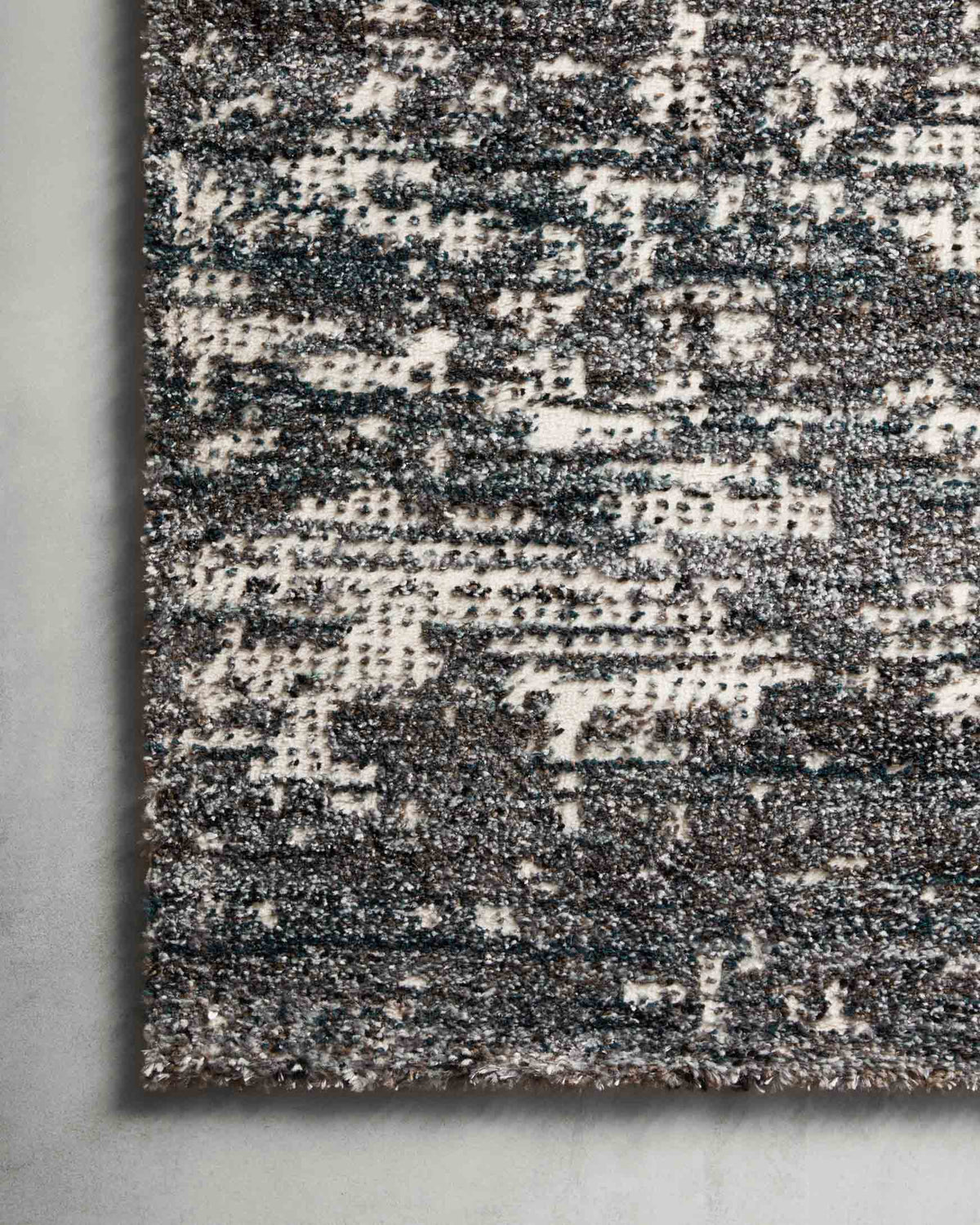 Close-up of dark denim and off-white speckled rug texture with low pile
