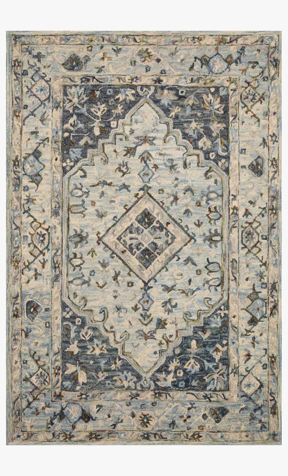 Light blue traditional hooked rug with blue and dark motifs and central diamond pattern.