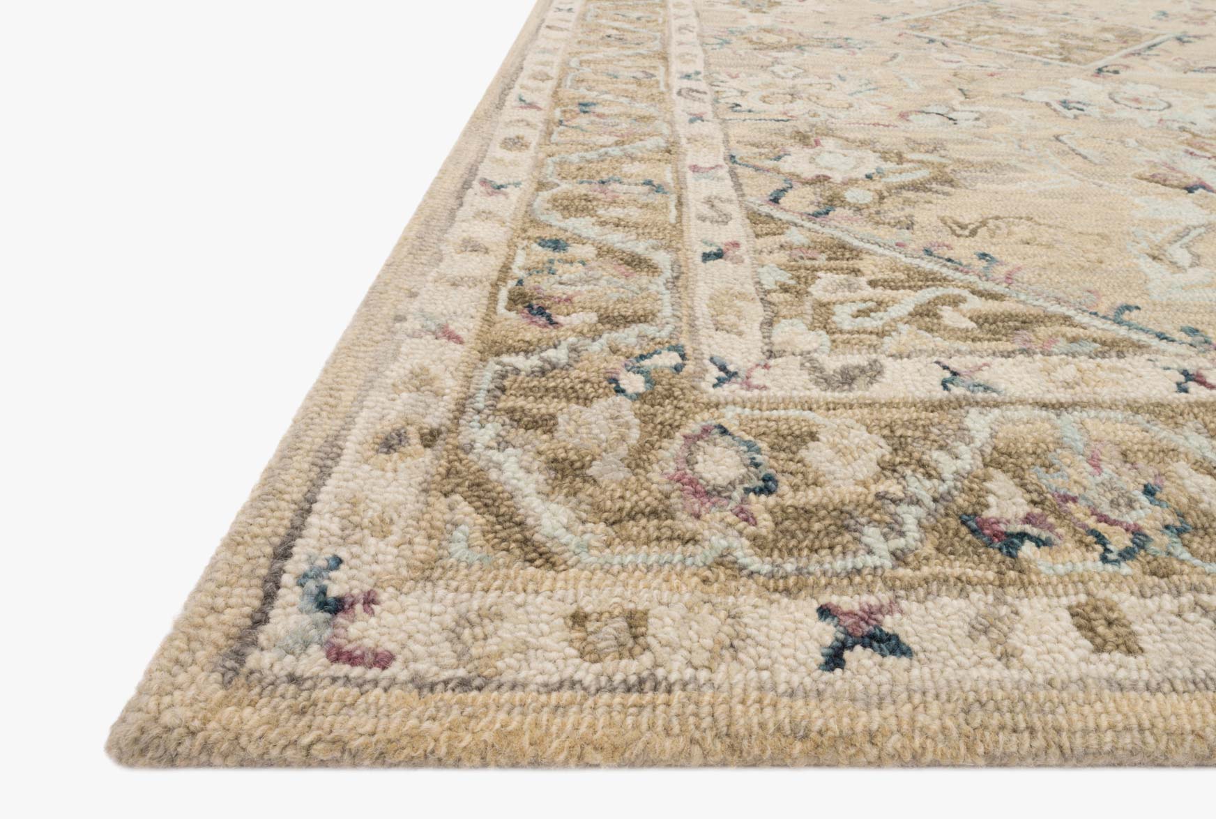 Close-up of beige and ivory hooked rug corner with multicolor floral and geometric motifs.