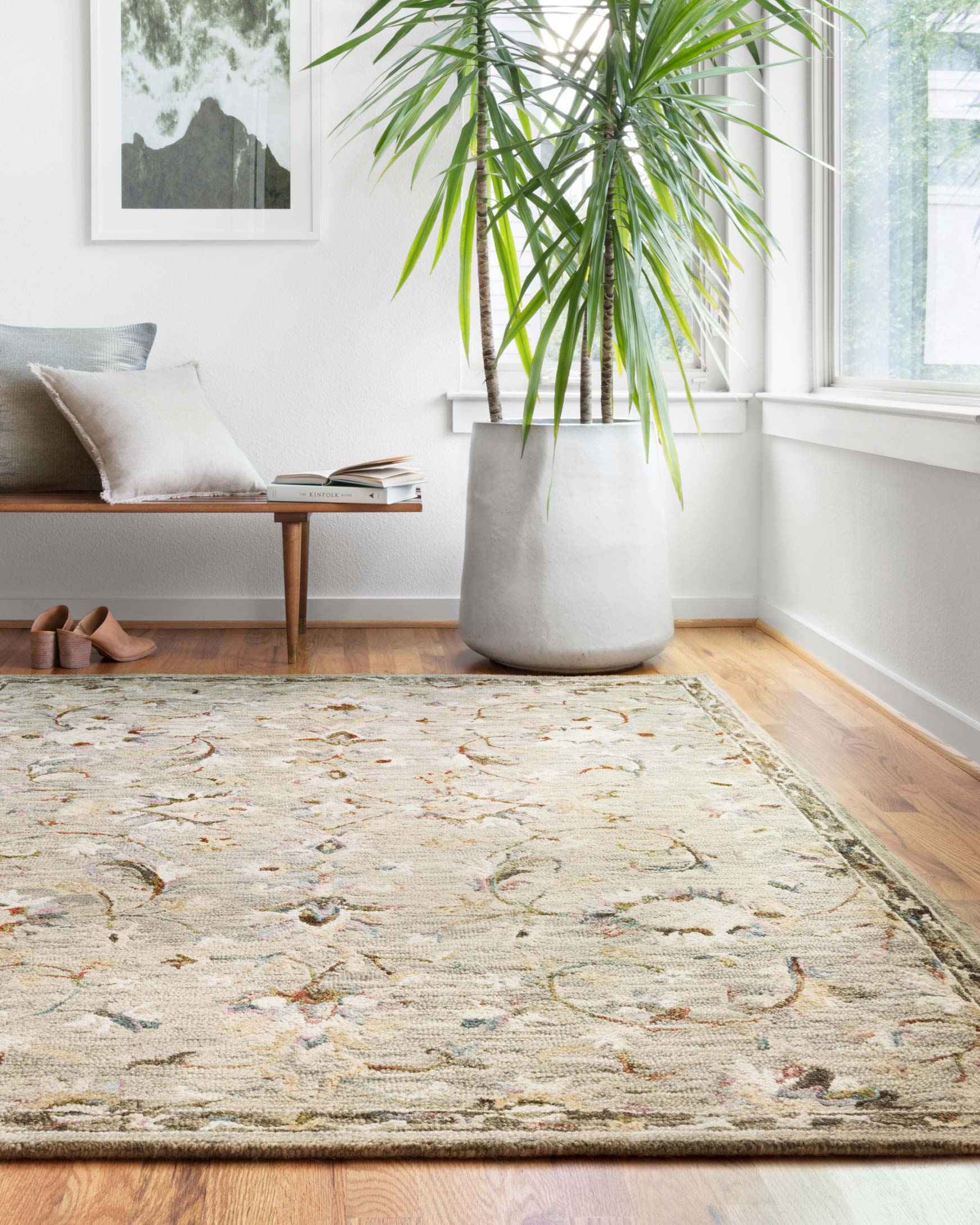 Traditional hooked rug with light grey floral vine design on hardwood floor