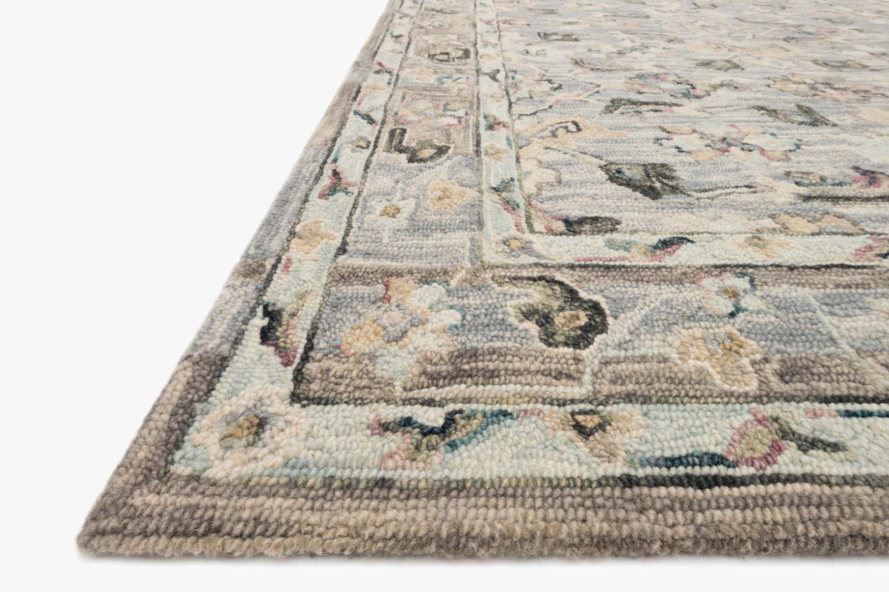 Light blue traditional hooked rug corner with textured border and multicolor motif