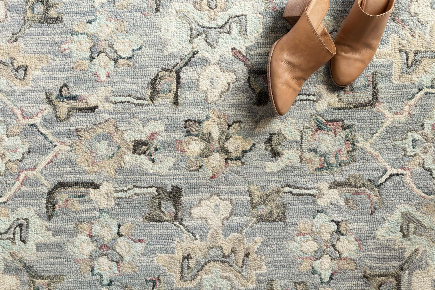 Close-up of light blue hooked rug pile with multicolor ornamental pattern