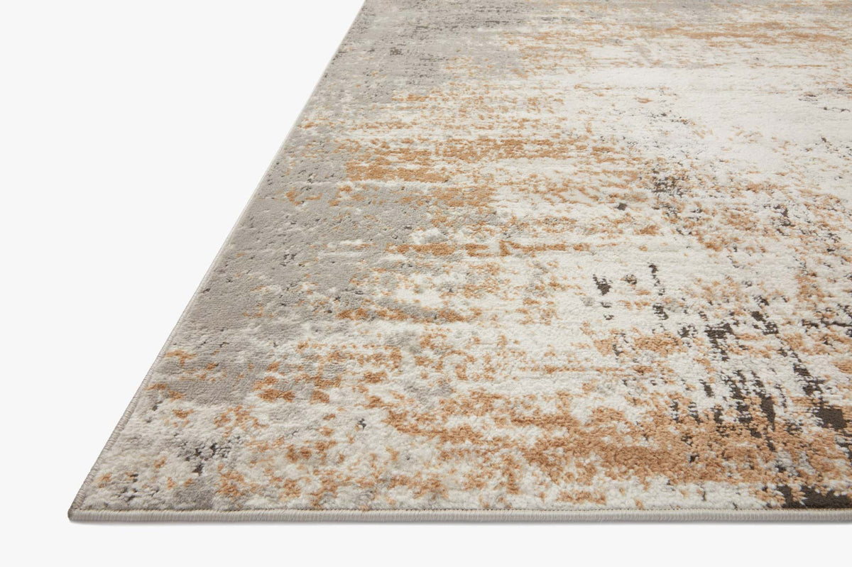 Corner view of stone and gold abstract rug with distressed speckle pattern