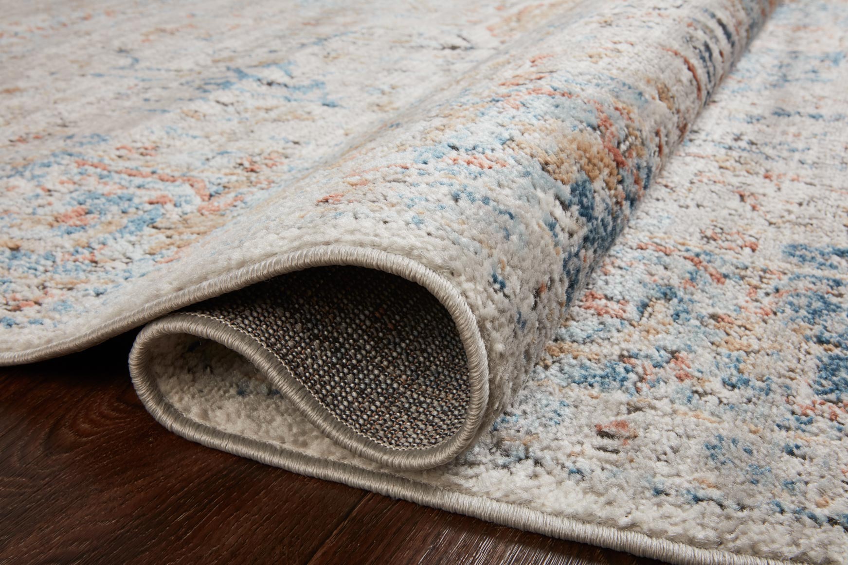 Stone abstract rug rolled edge showing textured weave in blue and orange tones