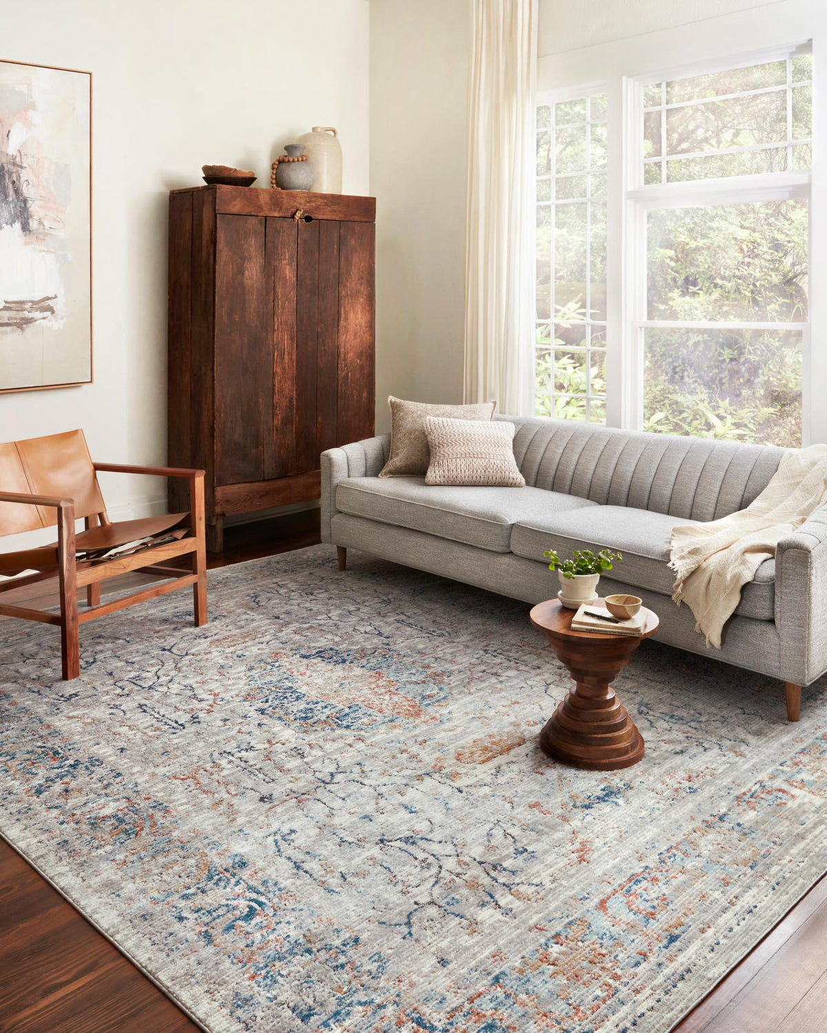 Stone abstract area rug with distressed blue motif and subtle orange accents