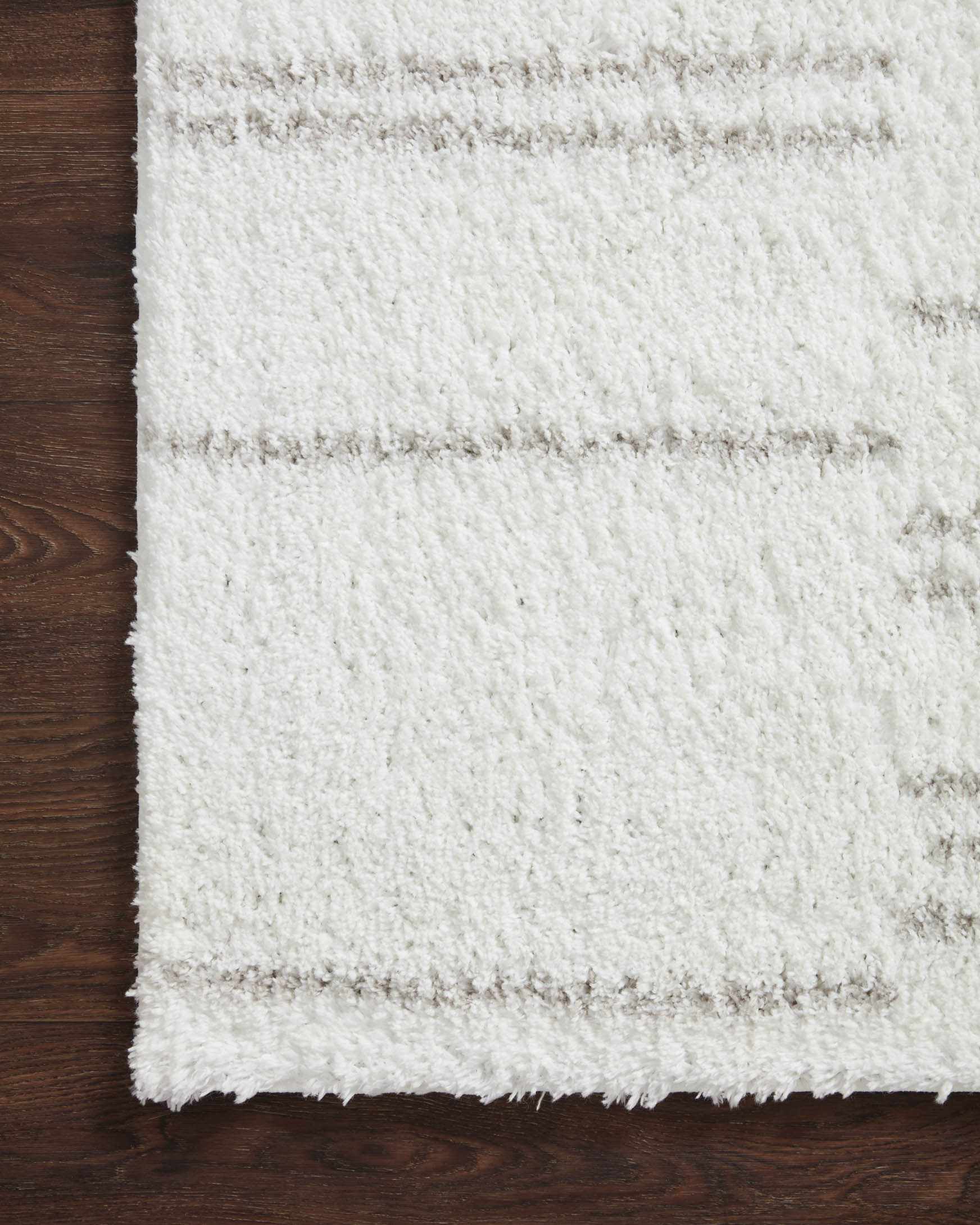 White shag rug with horizontal grey-tinted stripes and textured flat border