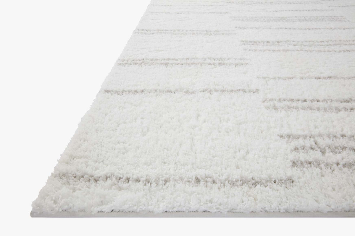 White shag rug corner with soft pile and light grey horizontal band