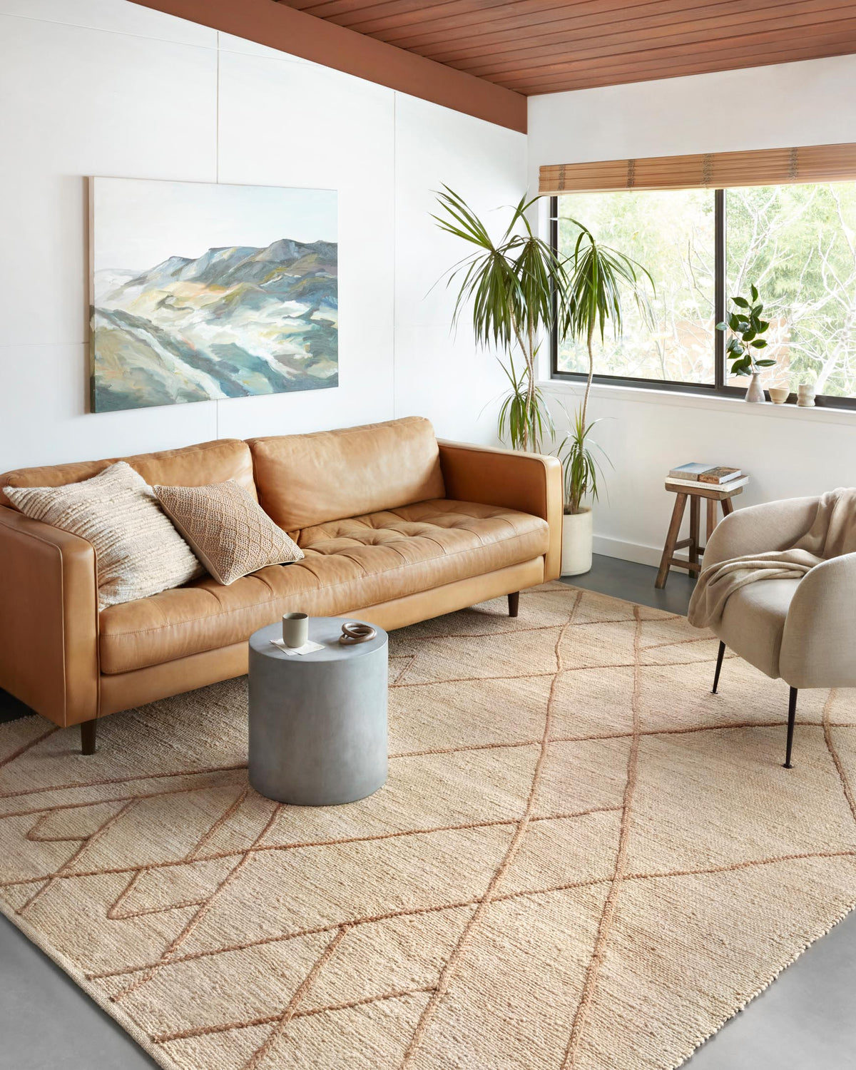 Contemporary hand-woven rug on floor with ivory field and tan diamond lattice lines