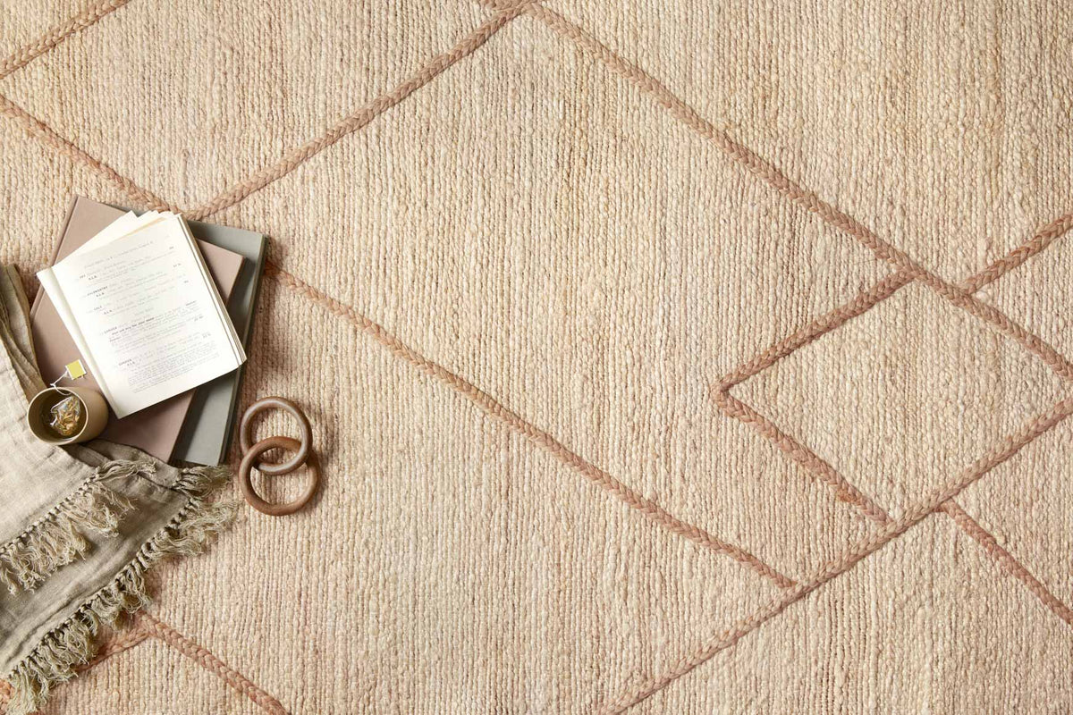 Close-up of hand-woven rug texture with ivory ground and tan diamond lattice pattern