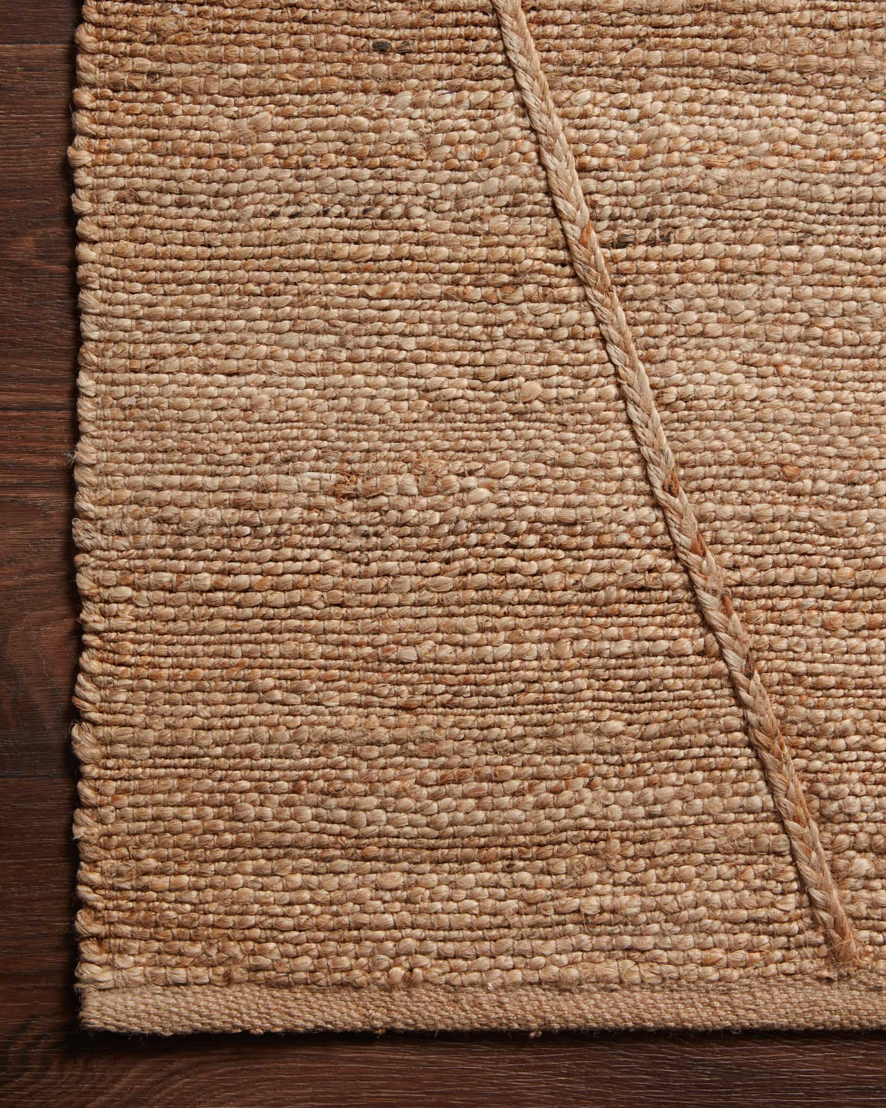 Natural tan rug corner detail with stitched edge and tightly woven texture