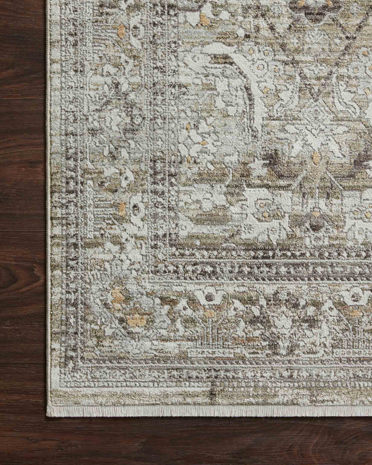 Moss and stone area rug edge with detailed ornament pattern and tightly bound border