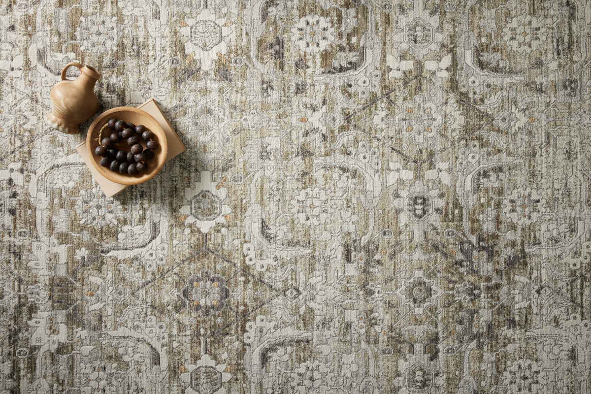 Moss and stone area rug close-up with dense ornamental motif and woven texture