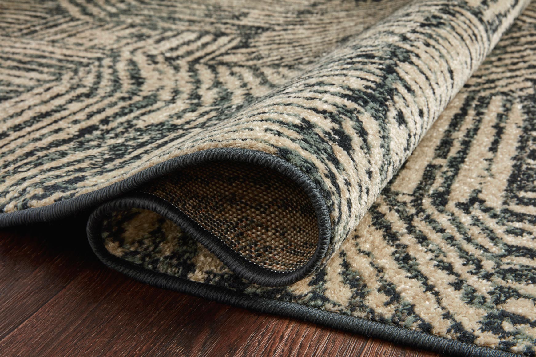 Close-up edge of midnight and taupe rug with bound border and cut-pile texture