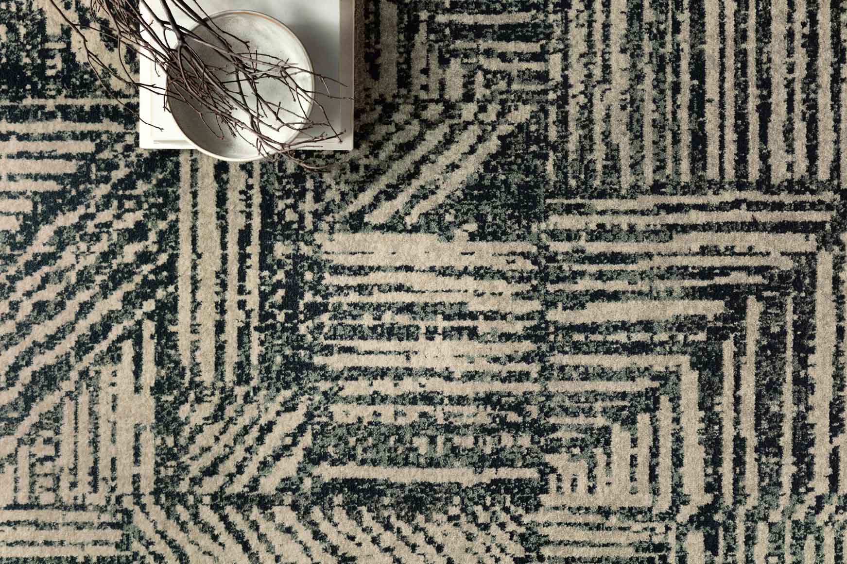 Close-up of midnight and taupe rug with bold geometric linework and texture