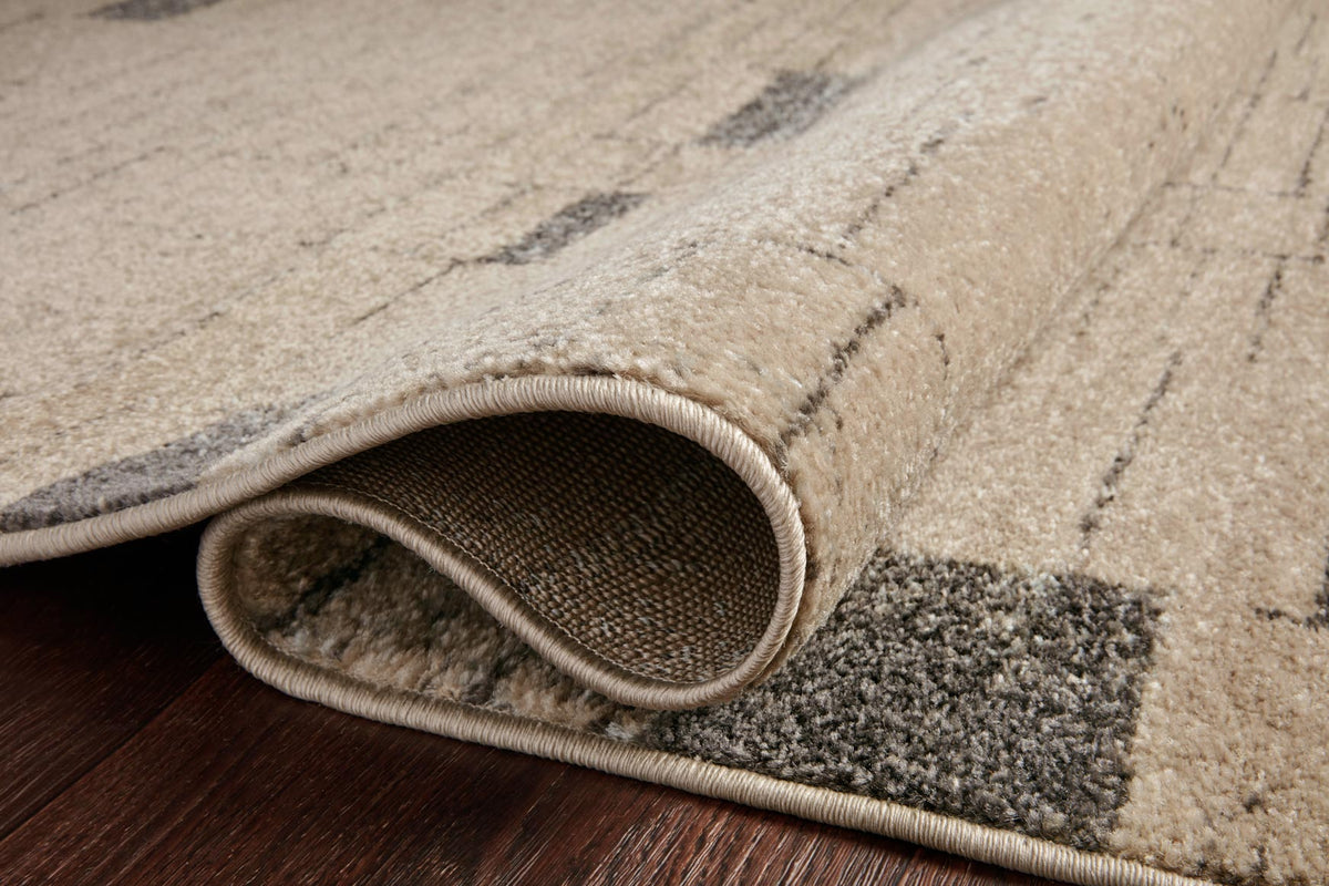 Close-up of slate and taupe rug edge with bound border and low pile