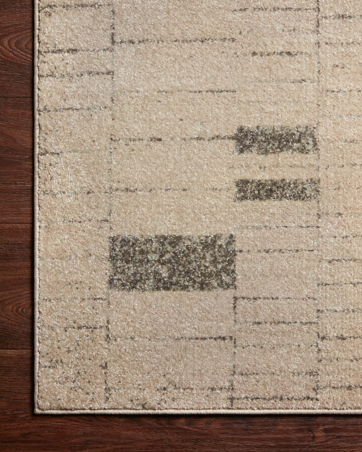 Close-up of slate and taupe geometric rug pattern with dark block details