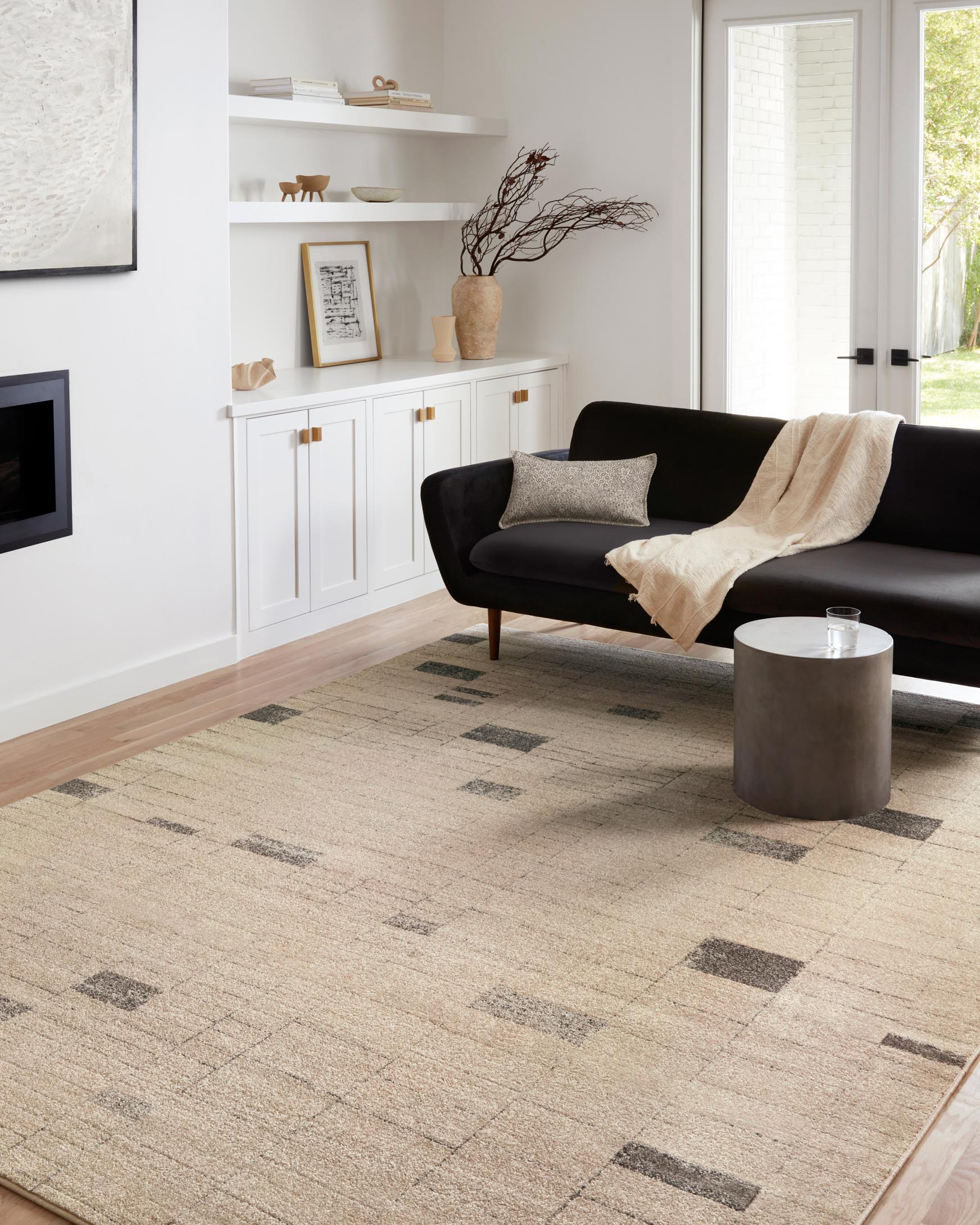 Contemporary slate and taupe geometric rug lying flat in a living room setting