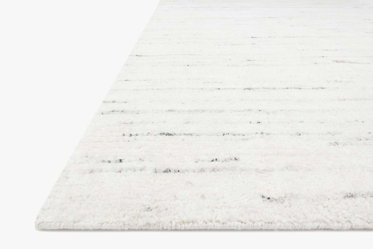 Hand-loomed rug corner with soft pile and horizontal ivory-and-stone stripe pattern