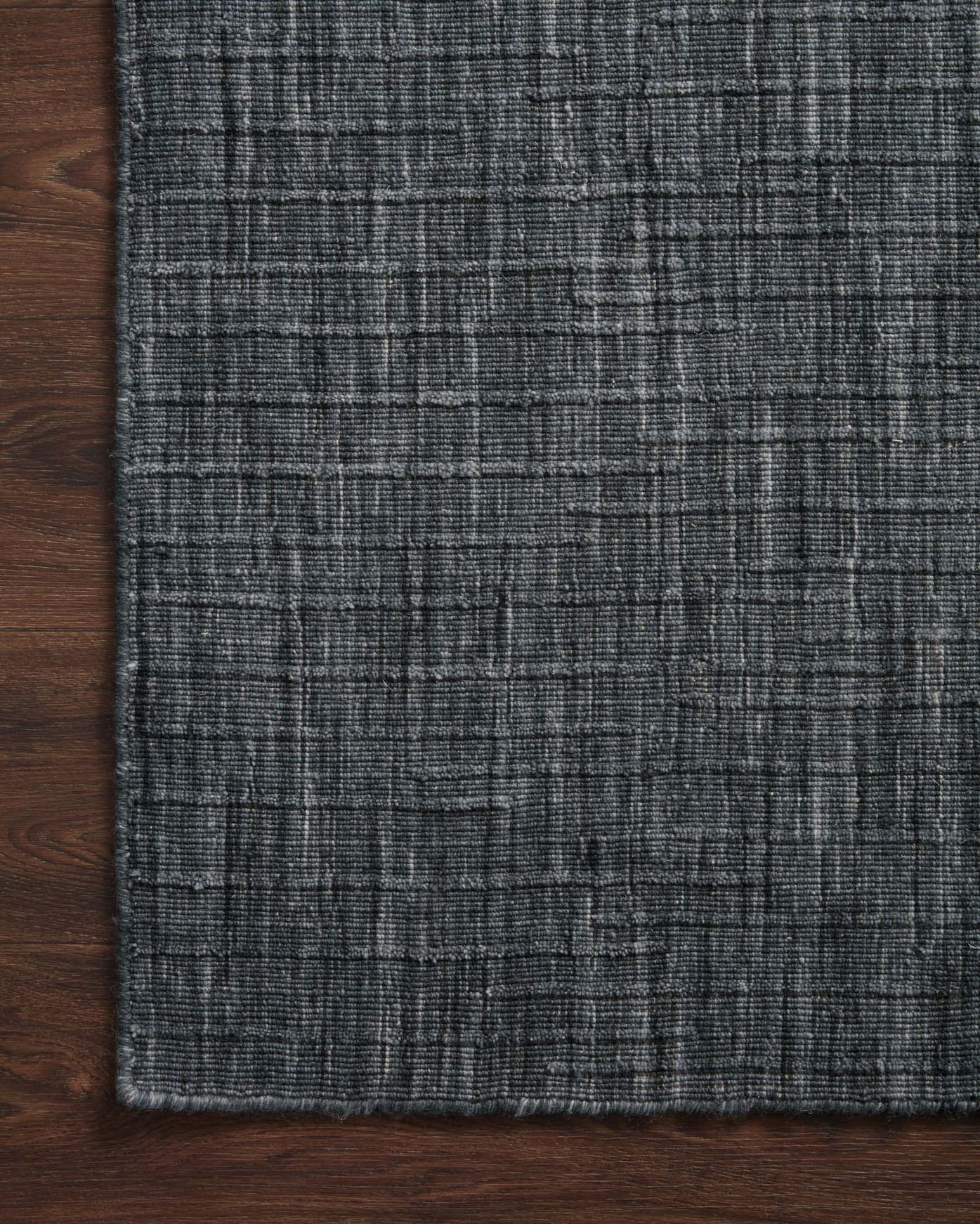 Ink blue hand-woven area rug with textured grid pattern and tight woven weave